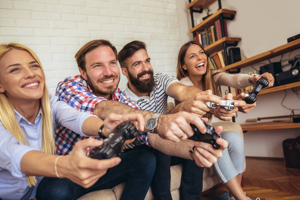 Group of friends play video games together. - Photo, Image