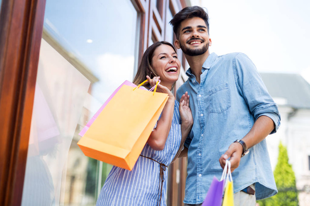 Happy attractive loving couple enjoy spending time in shopping together - Photo, Image