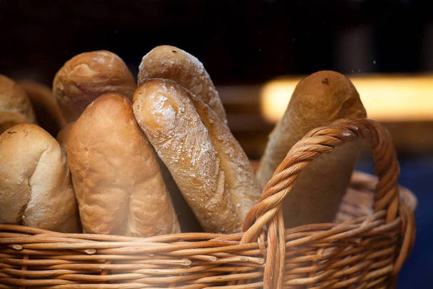 Хлебные хлебы и багеты в плетеной корзине. Хлеб в корзине в пекарне
 - Фото, изображение