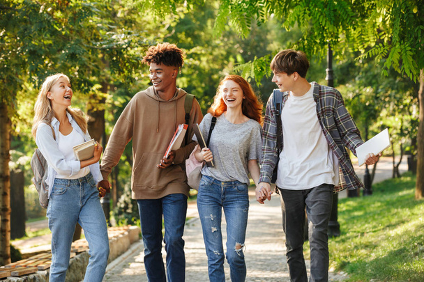 Group of laughing students walking at the campus outdoors - Foto, imagen