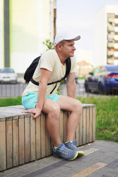Współczesne życie w wielkim mieście - sportowy młodego człowieka na ławce w mieście - Zdjęcie, obraz