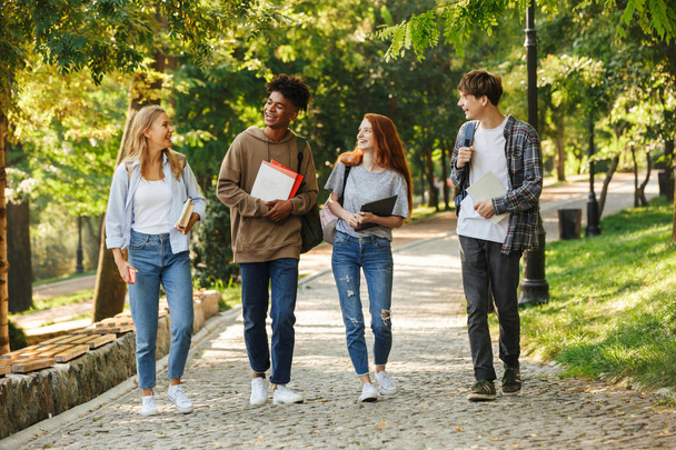 Група щасливих студентів, які ходять в кампусі на відкритому повітрі
 - Фото, зображення