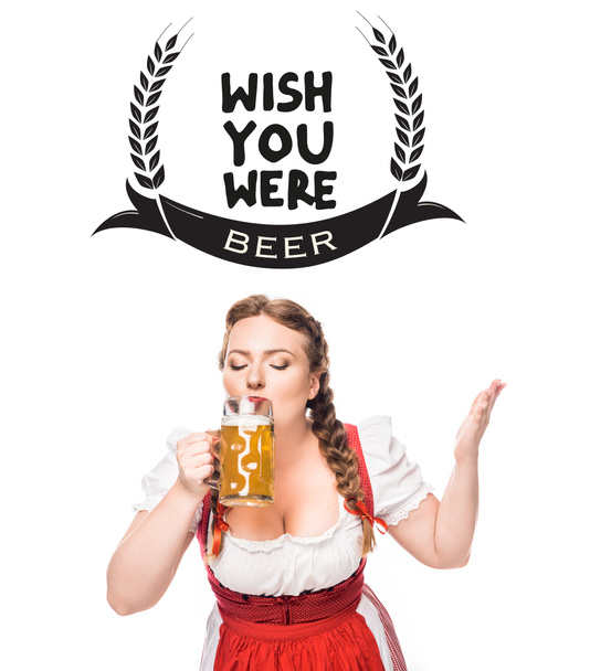 oktoberfest waitress in traditional bavarian dress drinking light beer isolated on white background with "wish you were beer" inspiration - Photo, Image