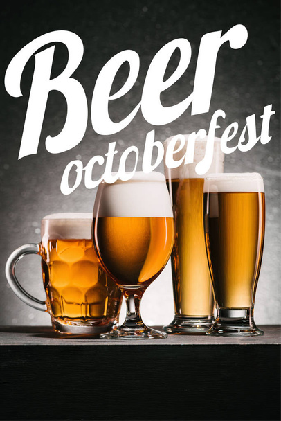 mugs of beer on grey background with "beer octoberfest" lettering - Фото, изображение