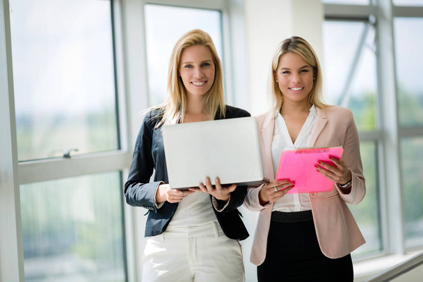 Smiling businesswomen talking and working together in bright office - Photo, image