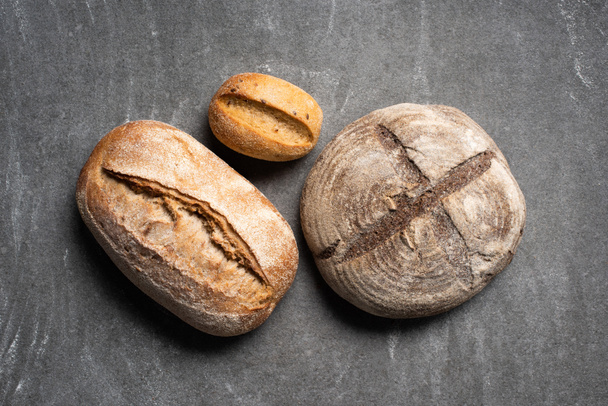 bovenaanzicht van loafs ciabatta brood op grijs tafelblad - Foto, afbeelding