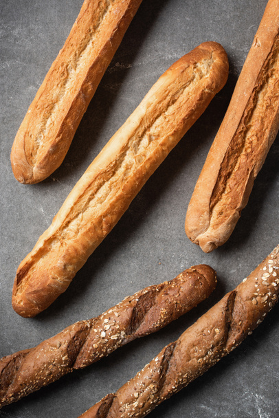 full frame of arranged loafs of baguettes on grey tabletop - Photo, Image