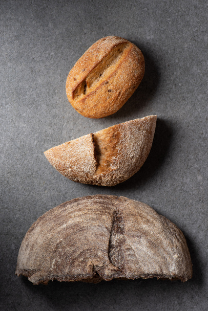 flat lay with halves of bread on grey surface - Photo, Image