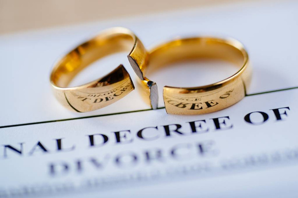 Due fedi nuziali d'oro rotte divorzio decreto documento. Concetto di divorzio e separazione
 - Foto, immagini