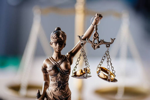Развод и семейное право. Статуя правосудия и сломанные обручальные кольца. Концепция развода и развода
 - Фото, изображение