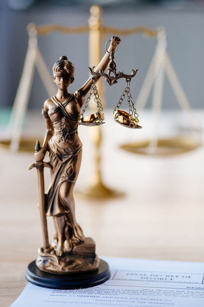 Развод и семейное право. Статуя правосудия и сломанные обручальные кольца. Концепция развода и развода
 - Фото, изображение