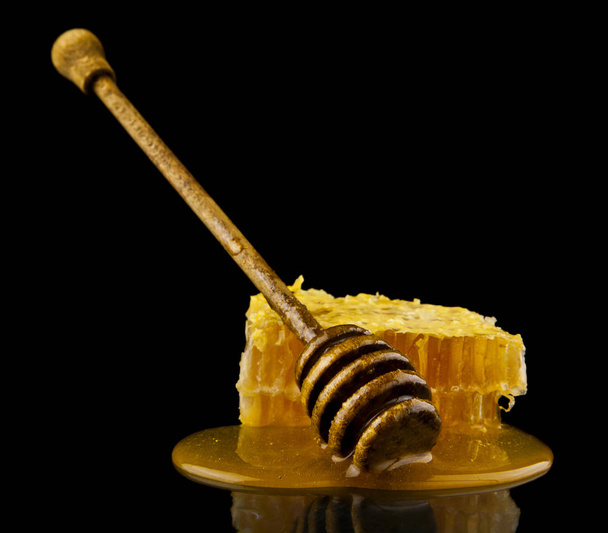rayon de miel avec cuillère à miel isolé sur fond noir, concept d'ingrédients naturels abeille
 - Photo, image