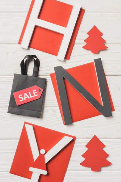 top view of lettering happy new year and shopping bag with sale sign on wooden table - Fotografie, Obrázek