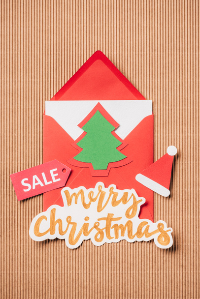 elevated view of greeting envelope, lettering sale and merry christmas on surface - Фото, зображення