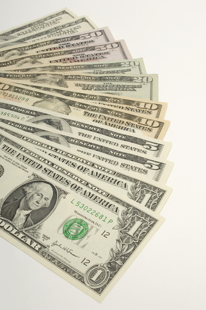 Dólares arranjados sobre fundo branco
 - Foto, Imagem