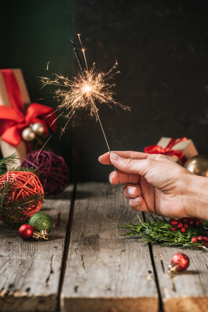 cropped view of woman holding christmas sparkler - Фото, зображення