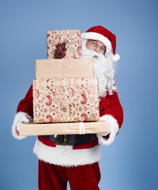 Portrait de Père Noël claus tenant pile de cadeaux de Noël
 - Photo, image