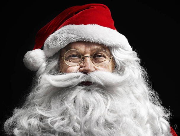 Человеческое лицо Санта-Клауса на черном фоне
 - Фото, изображение