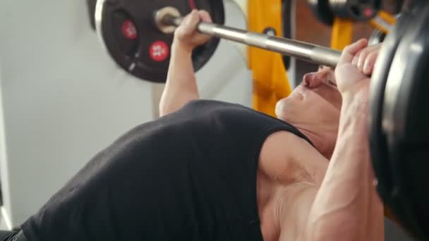 Bodybuilder performing incline barbell press exercise on a bench in the gym. Close up - Πλάνα, βίντεο