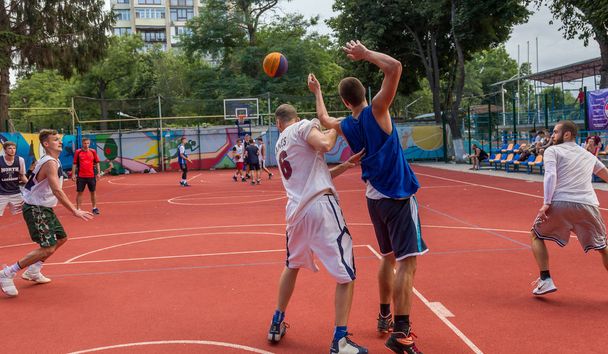 ODESSA, UKRAINE - JULY 28, 2018: Adolescents play basketball during 3x3 streetball championship. Young people play street basketball on an open city sports ground. Streetball - street cultures - Photo, Image