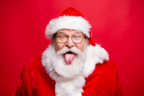 Best party time concept. Close up portrait of aged stylish cheerful Saint Nicholas with sticking tongue out look at camera fooling around isolated on noel vivid red background - Fotoğraf, Görsel