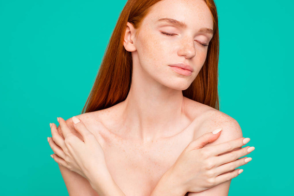 Advertising concept. Close-up portrait of nice perfect nude red-haired girl with shiny pure clean fresh smooth flawless skin, hugging herself, closed eyes, isolated over green turquoise background - Valokuva, kuva