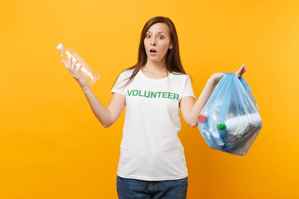 Femme en t-shirt volontaire, sac poubelle isolé sur fond jaune. Aide volontaire gratuite, grâce caritative. Problème de pollution environnementale. Arrêter la nature déchets environnement protection concept
 - Photo, image