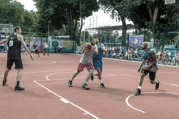 ODESSA, UKRAINE - 28 JUILLET 2018 : Les adolescents jouent au basketball pendant le championnat de streetball 3x3. Les jeunes jouent au basket-ball de rue sur un terrain de sport ouvert de la ville. Streetball - cultures de rue
 - Photo, image