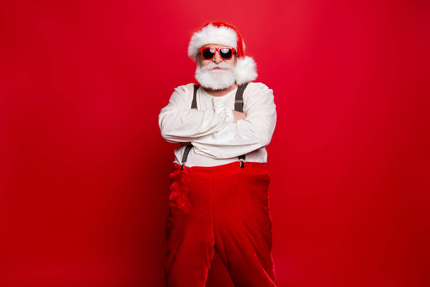 Portrait of stylish decisive content confident Santa wearing suit suspenders prepared ready for feast festive party promo sale promotion discount isolated over red background - Foto, Bild