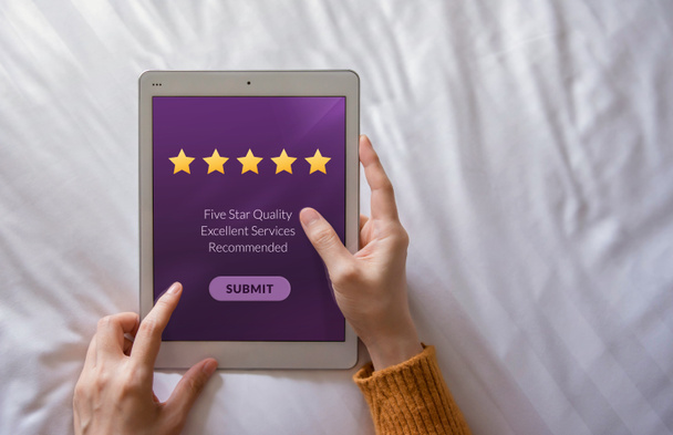 Koncept zkušenosti zákazníků. Šťastný klienta pomocí Tablet na posteli k psaní pozitivní hodnocení a odeslání zpětné vazby Online - Fotografie, Obrázek