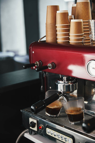 vergrote weergave van de voorbereiding van de machine van de professionele koffie koffie in twee glazen - Foto, afbeelding