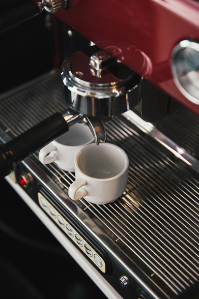 vista de ángulo alto de la máquina de café y dos tazas con espresso en la cafetería
 - Foto, Imagen