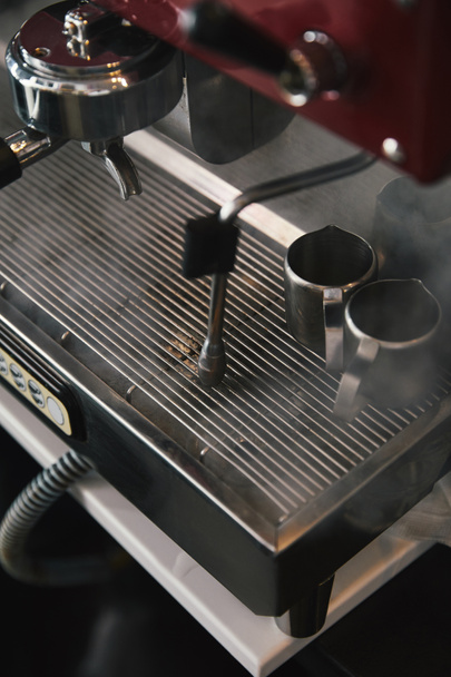 vergrote weergave van professionele koffiemachine met stoom in koffiehuis - Foto, afbeelding