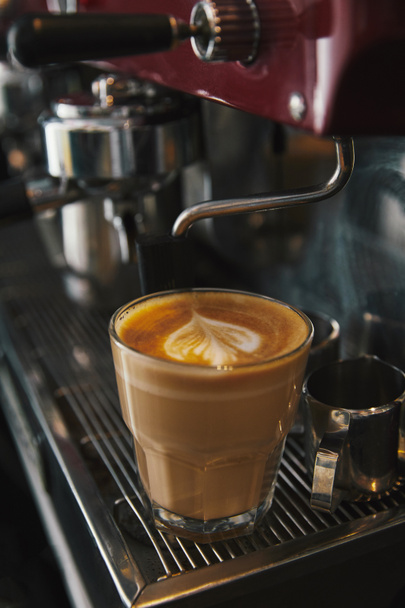 professionele koffie-/ theevoorzieningen en glazen beker met cappuccino  - Foto, afbeelding