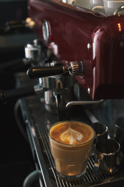 close-up view of coffee machine and glass cup with cappuccino  - Photo, Image