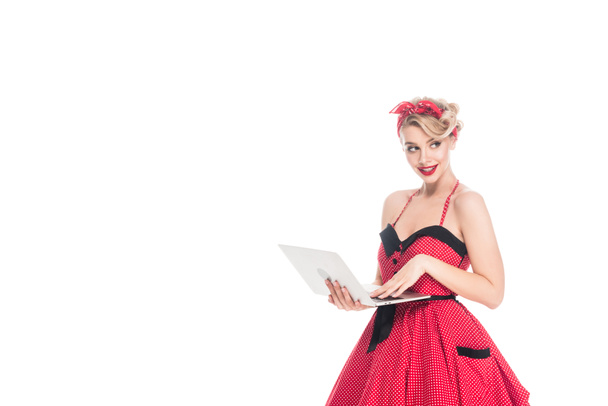 Portret van mooie vrouw in pin-up stijl kleding met laptop geïsoleerd op wit - Foto, afbeelding