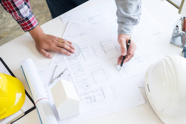 Közelkép személy mérnök kézi rajz terv a kék Print építész berendezések, építészek megvitatni az asztalnál, team munka és munka áramlás építési koncepcióját. - Fotó, kép