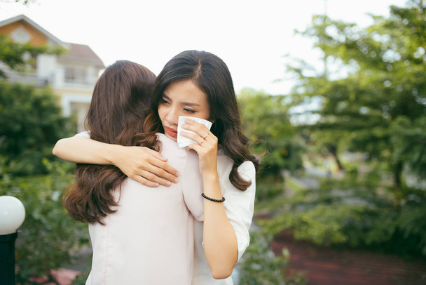 Portrait two women. Sad unhappy young woman being consoled by her friend. Friendship help support and difficult times concept. Human emotions feelings - 写真・画像
