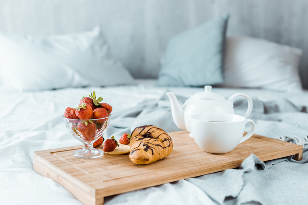 close-up view of tasty breakfast on wooden tray on bed  - Photo, Image