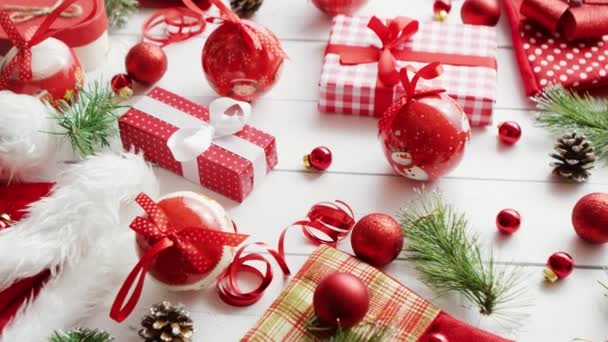 Tűlevelű gallyak és közelében ajándékok karácsonyi baubles - Felvétel, videó