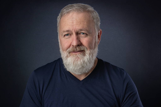 Happy 60 year old man with gray beard posing in the studio - Photo, Image