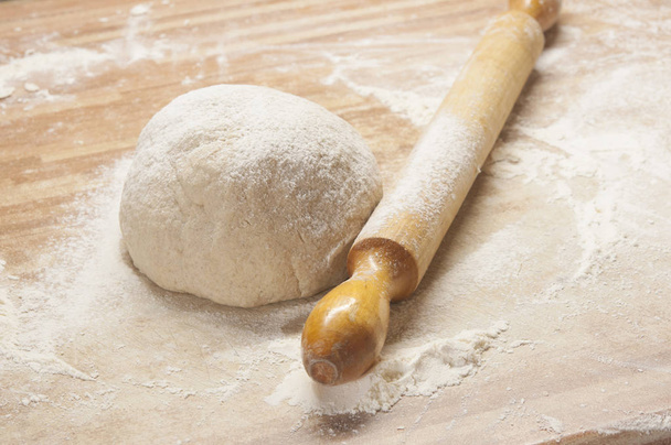 yeasty dough and rolling pin on wooden surface - Photo, Image