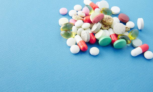 Tabletták vannak szétszórva a kék háttér - Fotó, kép