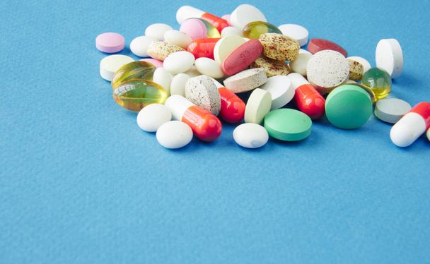 Tabletták vannak szétszórva a kék háttér - Fotó, kép