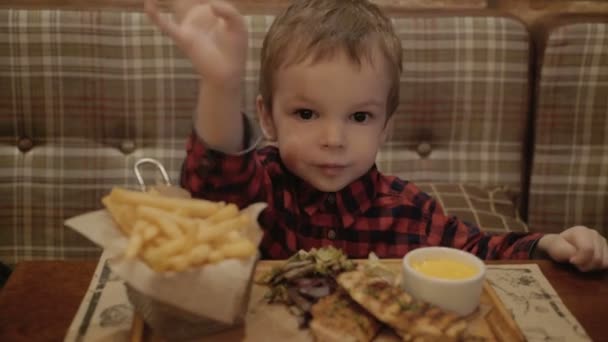 két éves fiú egy étteremben eszik sült krumpli. - Felvétel, videó