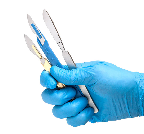 Skalpell in den Händen des Arztes in Handschuhen isoliert auf weißem Hintergrund. Chirurg mit Messer vor der Operation - Foto, Bild