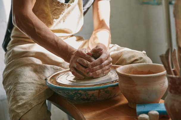 partial view of potter working on pottery wheel at workshop - Photo, Image