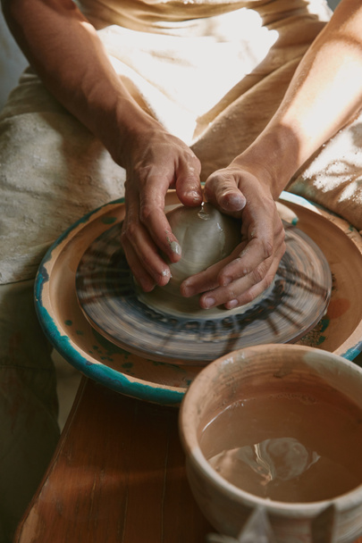 partial view of professional potter working with clay at workshop  - Foto, afbeelding