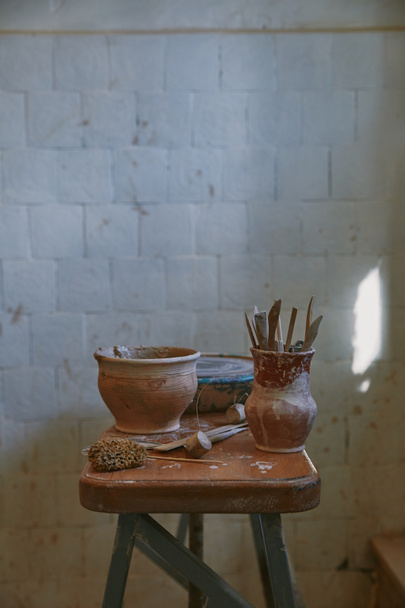 selectieve aandacht voor aardewerk tools aan tafel in aardewerk studio - Foto, afbeelding