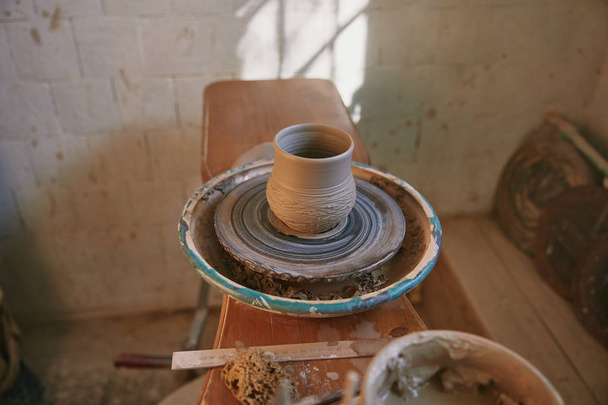 селективный фокус глиняного горшка на гончарном круге в мастерской
 - Фото, изображение